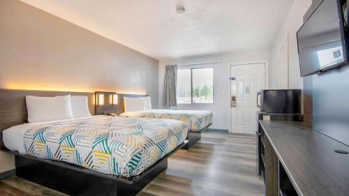 特克萨卡纳Studio 6 Texarkana TX的酒店客房设有两张床和一台平面电视。