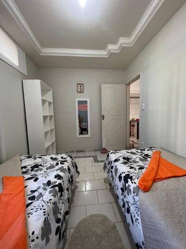 阿拉卡茹Casa temporada Aracaju的一间卧室配有两张黑白床单