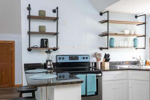 盖恩斯维尔Spacious Family Friendly Retreat 3 BD Loft的厨房配有白色橱柜和炉灶烤箱。