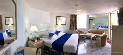 阿卡普尔科阿卡普尔科马里布酒店的酒店客房带一张大床和一把椅子