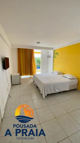 帕纳米林Pousada A Praia的一间卧室设有一张床和黄色的墙壁