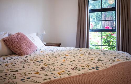 克莱德Clyde Central的一间卧室配有一张带花卉床罩的床和窗户。