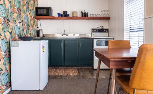 克莱德Clyde Central的厨房配有绿色橱柜和白色冰箱