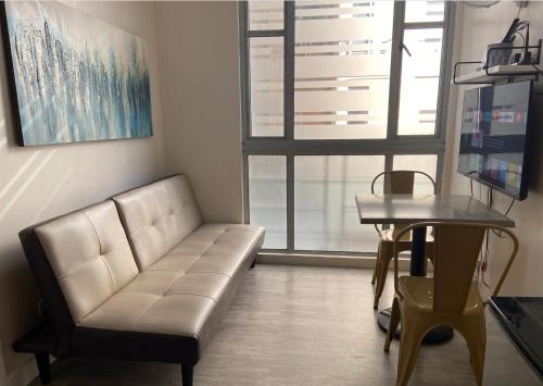 马尼拉Marikina Manila Condominium 1 Bedroom的客厅配有沙发和桌子