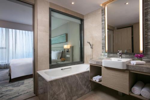 杭州杭州拱墅假日酒店的带浴缸、水槽和镜子的浴室