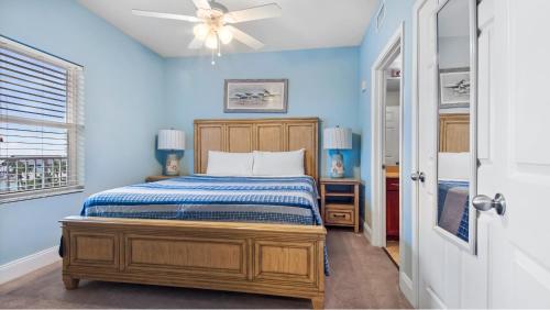 巴拿马城海滩Laketown Wharf #317 by Nautical Properties的蓝色卧室配有床和吊扇