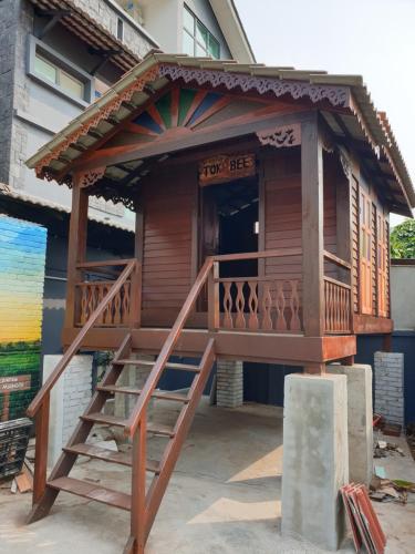 峇六拜Pondok Tok Bee的带阳台和楼梯的木屋