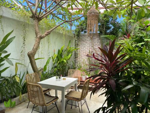 坎古丛林之家旅舍的花园内的白色桌椅