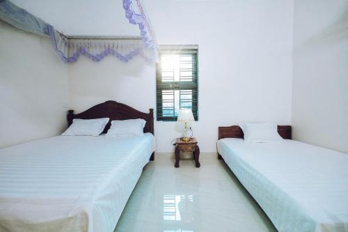 木州县Villa Habit 3br Center Mộc Châu的白色墙壁客房的两张床