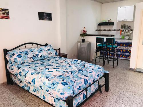 梅尔加GINEZ PRODUCTION COL的一间卧室配有一张带蓝色棉被的床