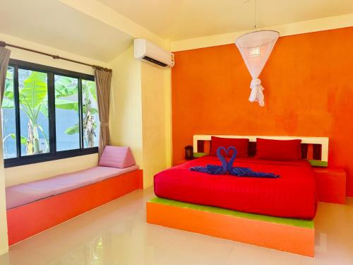 通萨拉大神田海滩别墅度假村的一间卧室设有红色的床和窗户。