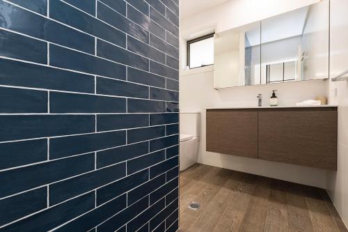 斯昆Gunsynd Studio Apartment的浴室设有蓝色瓷砖墙和水槽。