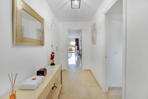 马贝拉Lujoso apartamento con alucinantes vistas al golf - Iwii A 38的白色走廊设有水槽和镜子