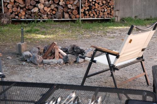 一軒家貸切 ARUYOguesthouse BBQと焚き火ができる宿的坐在一堆木头旁的椅子