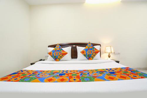 新德里FabHotel F9 NSP的一间卧室,床上有五颜六色的被子