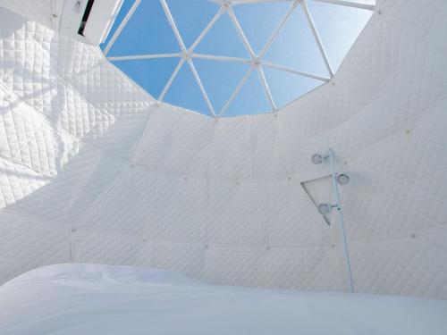 宫古岛GLAMTECH RESORTS HEAVEN的白色的客房设有玻璃天花板和淋浴