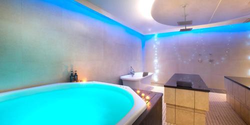 卡利登The Caledon Hotel and Spa的带浴缸和蓝色灯光卫生间的浴室