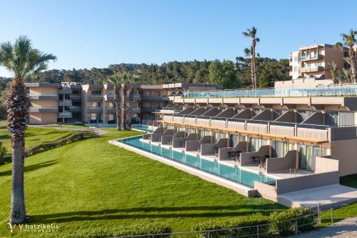 罗德岛卡利地亚Kresten Palace Hotel的一个带游泳池和棕榈树的度假村