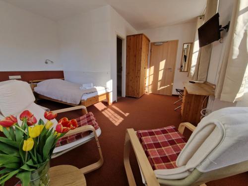 格尔利茨祖姆霍托特伽尼酒店的客厅配有床和鲜花桌