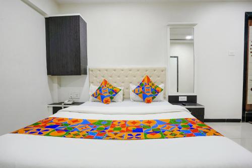 纳威孟买FabExpress Rajmahal的一间卧室配有一张大床和色彩缤纷的毯子