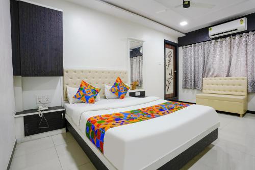 纳威孟买FabExpress Rajmahal的卧室配有一张带彩色枕头的大型白色床。