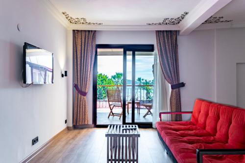 比泰兹Costa Bitezhan Hotel - All Inclusive的一间带红色沙发的客厅和一个阳台