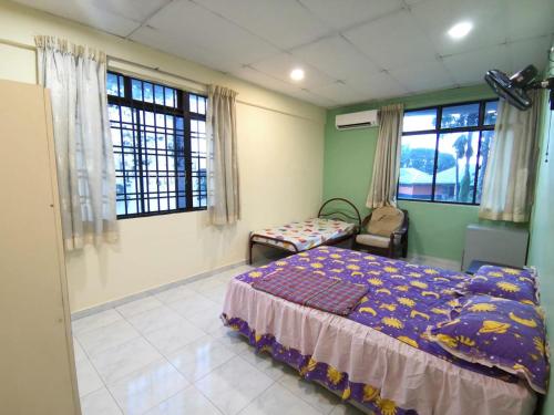 乌鲁地南Cosy Homestay Ulu Tiram的一间卧室配有一张床、一把椅子和窗户。