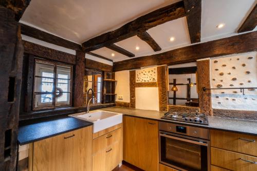 阿德瑙Haus zum Ring的厨房配有木制橱柜、水槽和炉灶。