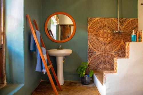 巴加莫约Firefly Boutique Lodge的一间带水槽和镜子的浴室