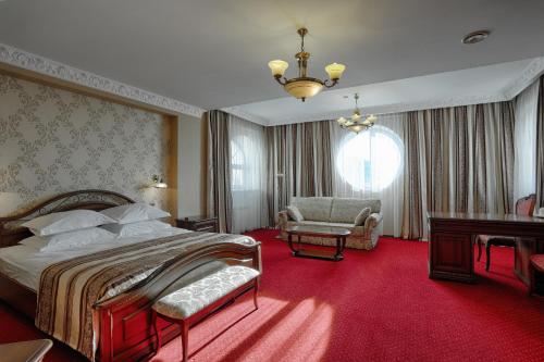 伊尔库茨克欧罗巴酒店的一间卧室配有一张大床,铺有红地毯