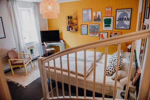 策勒sleepArt room for 2的一间带婴儿床的卧室和一间带电视的客房。
