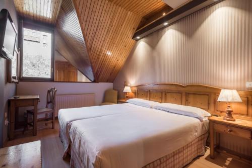 福米加尔Snö Villa de Sallent 3的一间卧室配有一张床、一张书桌和一个窗户。