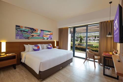 班查內加拉FOX HARRIS Hotel & Convention Banjarnegara的酒店客房设有一张大床和一台电视。
