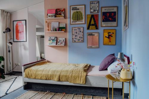 策勒sleepArt room for 3的一间卧室配有床和一张带照片的墙壁