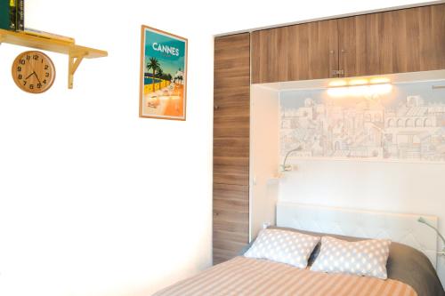 尼斯Haliviera - Golden Square, 1min from beach的卧室配有一张床,墙上挂着一个钟