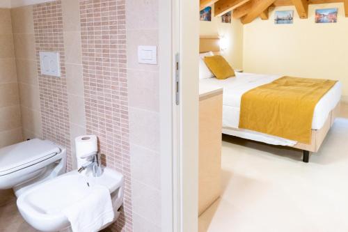马格拉Atika & Atif - Hotel Autoespresso Venice的一间带卫生间的浴室和一张位于客房内的床。