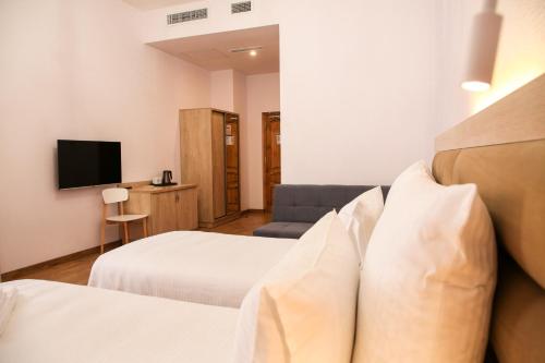 久姆里KUMA Hotel Gyumri的酒店客房设有两张床和电视。