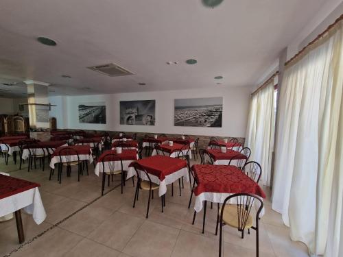 里米尼HOTEL CLARA RIMINI 30m from the beach的一间餐厅,房间内设有红色的桌椅