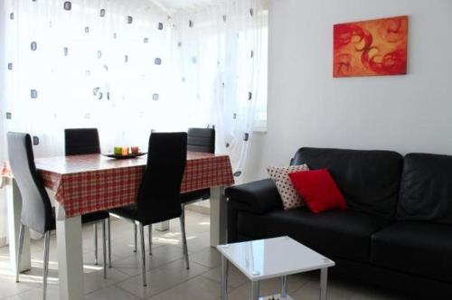 希贝尼克Apartment in Zaboric with sea view, balcony, air conditioning, WiFi 5178-2的客厅配有黑色沙发和桌子