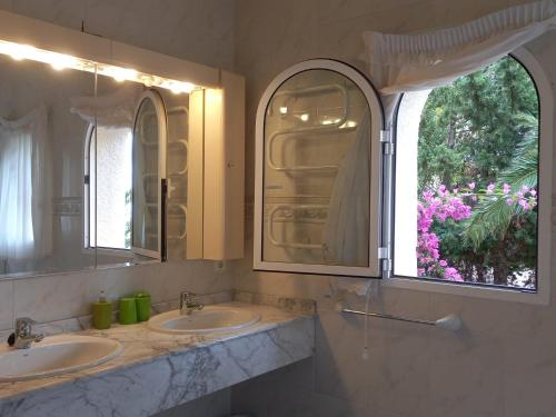 阿尔啼阿乐马尼亚别墅的一间带两个盥洗盆的浴室和一个大窗户
