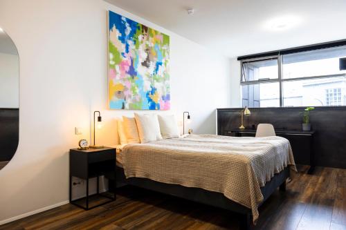 雷克雅未克Modern Downtown 1 BR Apartment的卧室配有一张床,墙上挂有绘画作品