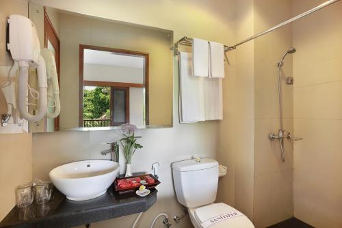 沙努尔若斯帕缇海滩酒店 的一间带水槽、卫生间和镜子的浴室