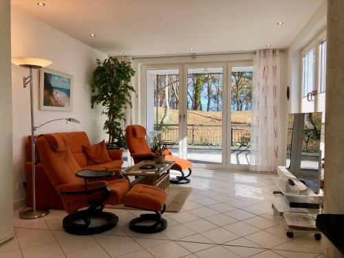 赛巴特班森Villa Marfa - FeWo 03的客厅配有橙色椅子和电视
