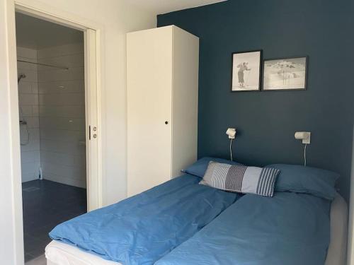 哈山Apartment in Hafjell / Øyer centre.的卧室内的一张床铺,卧室内有蓝色的墙壁