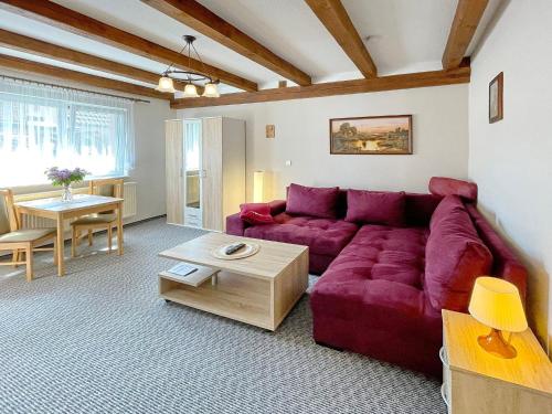 吕本瑙Ferienwohnung Hibiskus的客厅配有红色的沙发和桌子