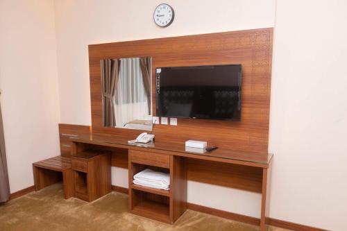 麦加فندق منار التوحيد 2的客房设有一张带电视和镜子的书桌。