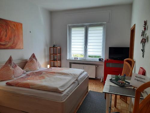 奥伯豪森3 x Ferien- & Monteurwohnungen Koenen nah am Westfield Centro的一间卧室配有一张床、一张桌子和一个窗户。