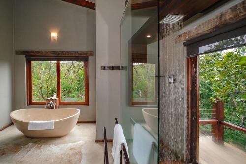 KwaNompondo犀牛岭野生山林小屋的带浴缸、水槽和淋浴的浴室