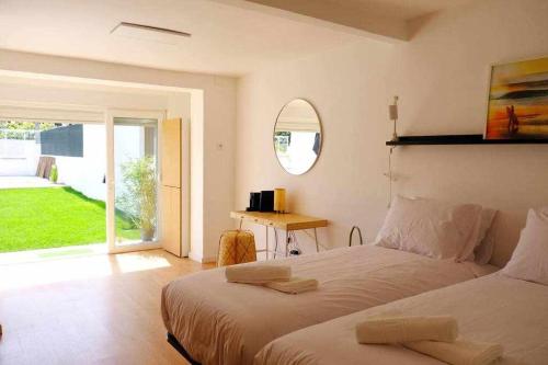 AroeiraSurfie Surf Beach e Adventure的一间卧室设有两张床、一张桌子和一个窗口