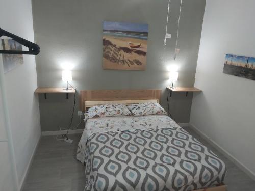 圣克鲁斯-德特内里费Guest House Santa Cruz的卧室配有一张床,墙上有两盏灯